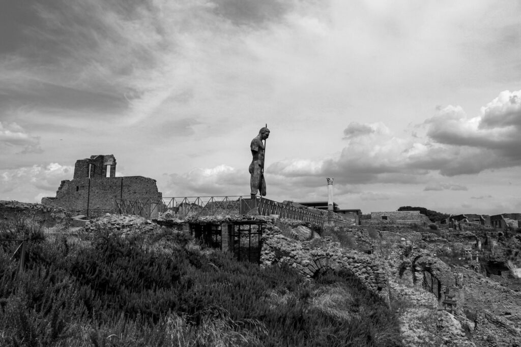 Monochrome view of ancient ruins and sculpture in Pompeii, Italy.